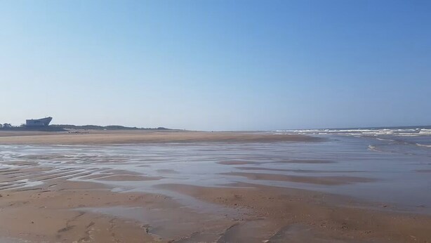 A beach with wet sand and gentle waves. - 2-bed -Sleeps 4 - Parking - Pets - 5 mins to Beach (Chapel St Leonards)