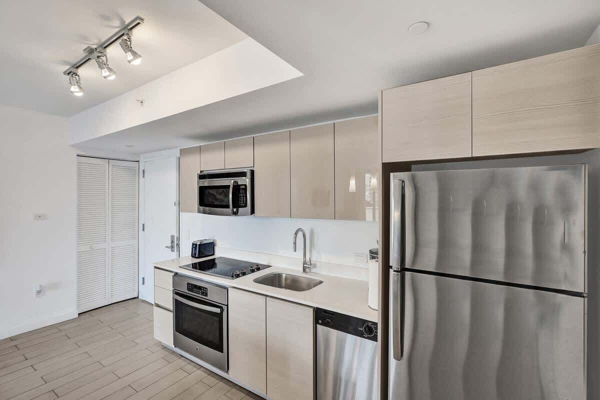 A modern kitchen with stainless steel appliances, a dishwasher, and a double sink.
