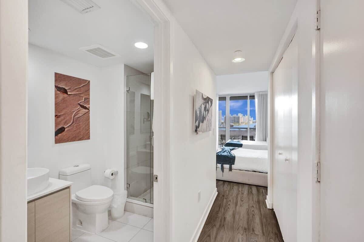 A modern bathroom with a toilet, sink, and glass shower enclosure.