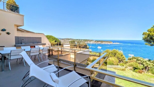 Una terraza con asientos al aire libre y vista al mar.