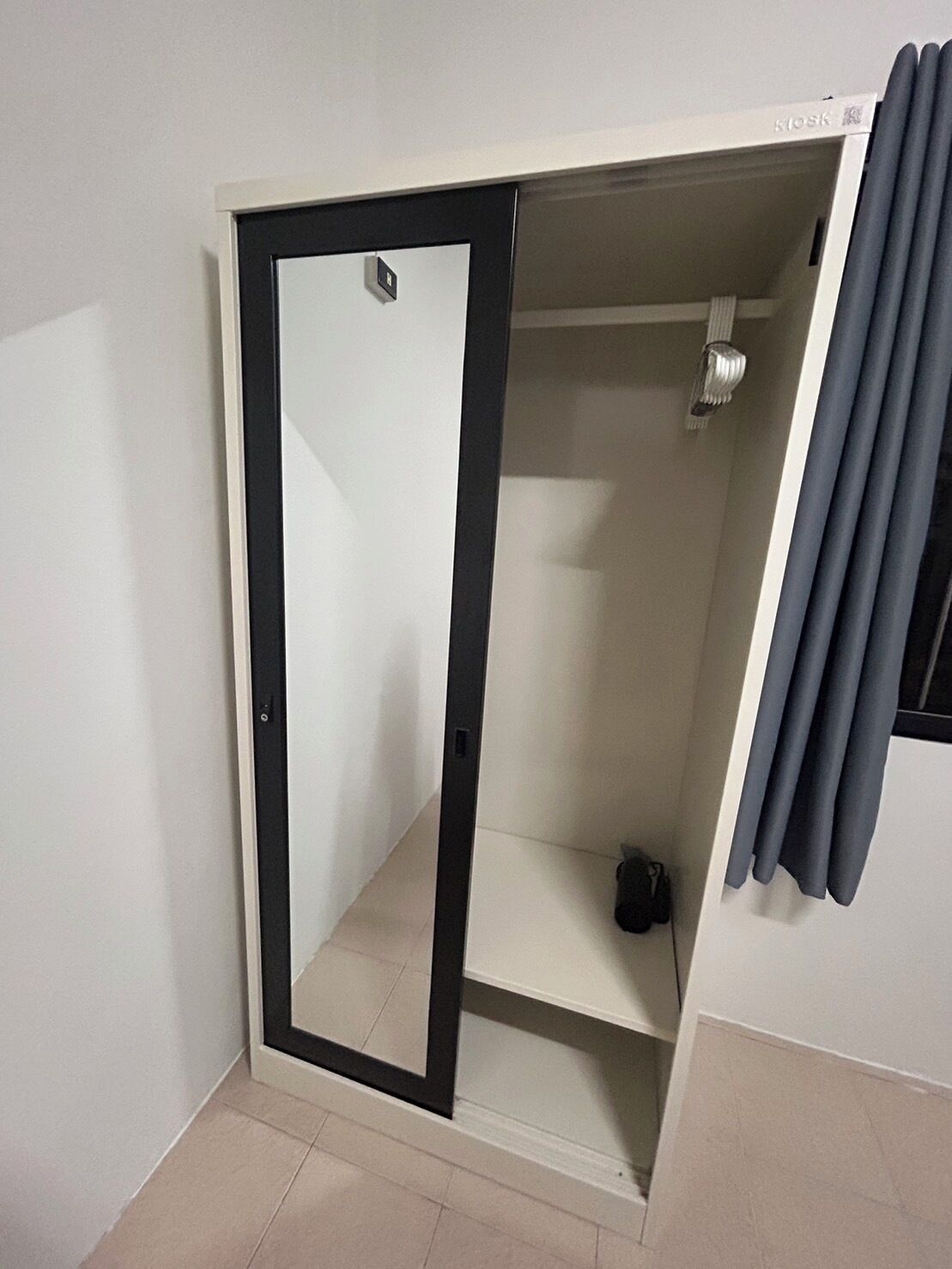 A room with a wardrobe, a shower, and a curtain.