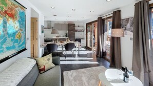 Una sala de estar moderna con un sofá, una mesa de comedor y una cocina al fondo.