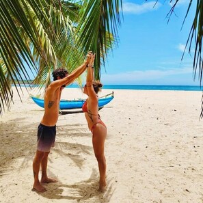 Pantai pribadi, pasir putih, kursi berjemur, dan handuk pantai
