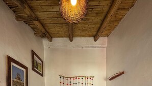A bedroom with a wooden ceiling, a bed with a white quilt, and two framed pictures on the wall. - SUMAQ QUINUA (Carmen Alto)