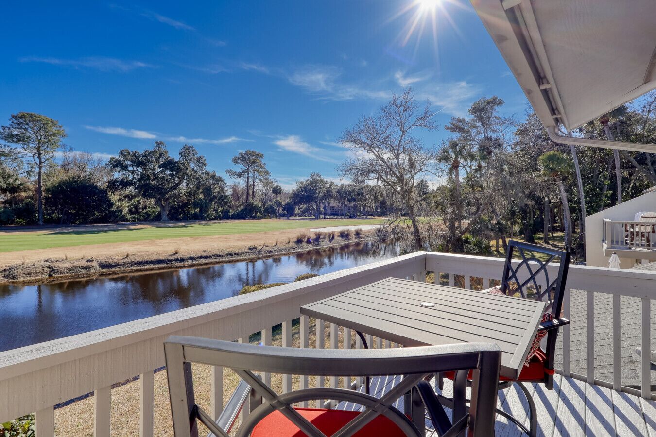 A deck with a view of a river and a golf course.