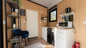 Une cuisine compacte équipée d’un four à micro-ondes, d’une machine à café et d’une petite fenêtre.