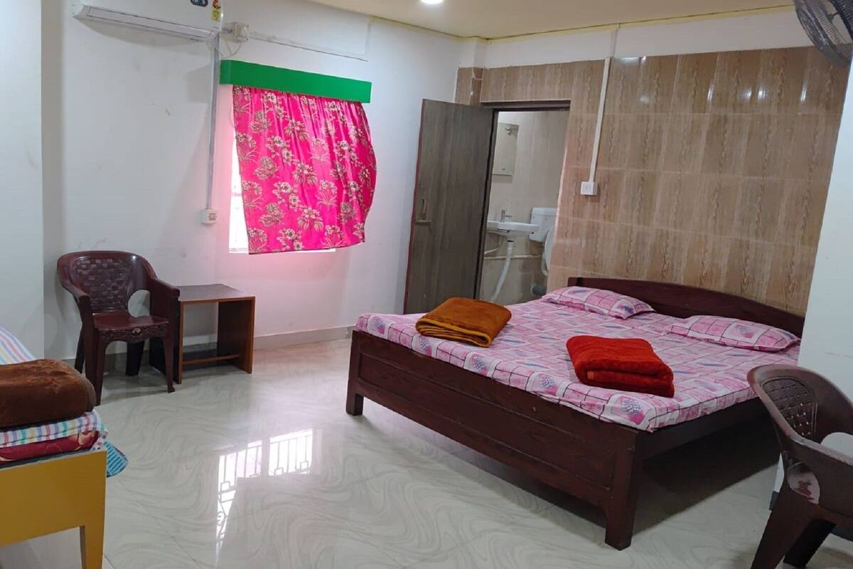 A bedroom with a bed, a chair, a desk, and a wardrobe.