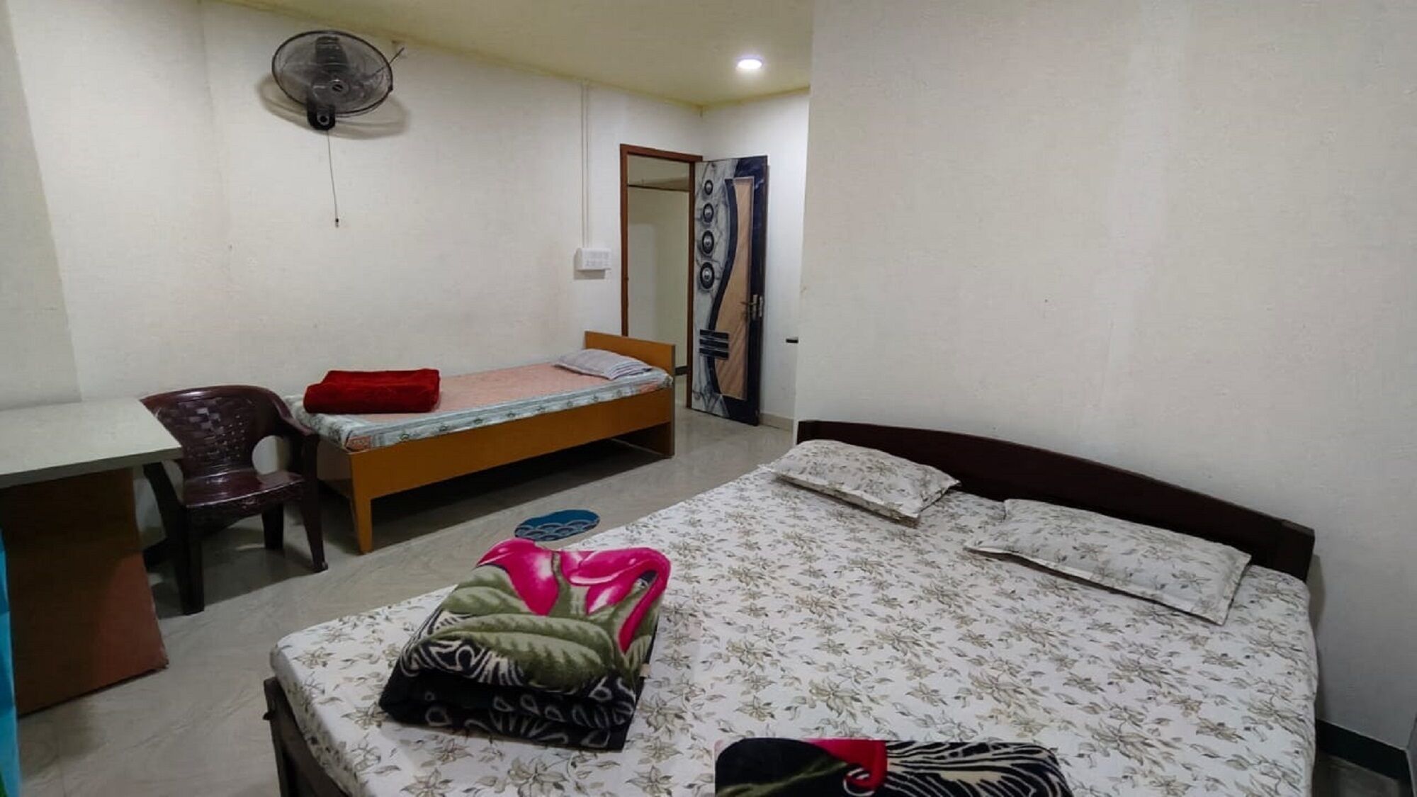 Um quarto pequeno e simples com uma cama, uma escrivaninha e uma cadeira.