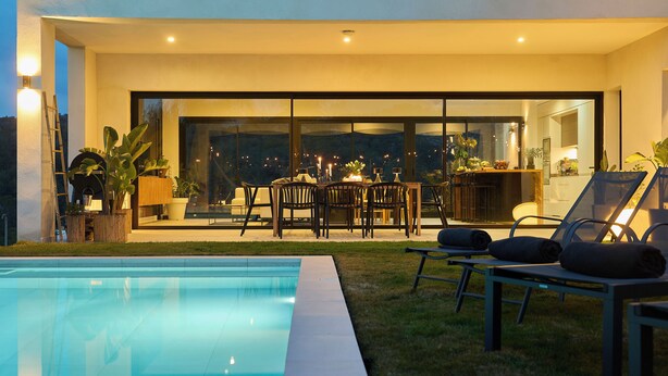 Un espace piscine extérieur moderne, aménagé avec un coin repas et des chaises longues.