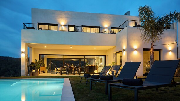 A modern two-story house with a swimming pool, outdoor seating, and a balcony with lights. - Villa Casa Selva - Luxury and nature only 7 minutes drive from Sitges (Sitges)