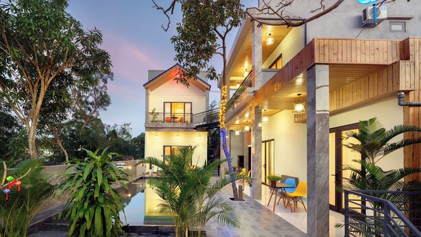 A modern hotel with a two-story structure, outdoor seating area, and a small pool. - Ha Blue Villa - Hoi An (Da Nang)