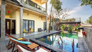 Piscine extérieure, parasols de plage, chaises longues