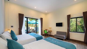 A hotel room with two beds, a desk, a chair, a sofa, and a TV. - Ha Blue Villa - Hoi An (Da Nang)
