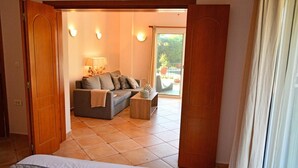 Une chambre avec un lit, un canapé, une table basse et une vue sur l’extérieur.