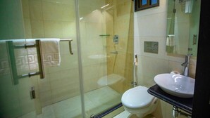 A modern bathroom with a glass-enclosed shower, a white toilet, and a sink with a mirror above it. - King S Crown (Barasat)