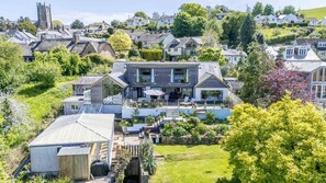 Una casa moderna con un ampio patio, un garage e un giardino curato.