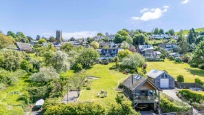 Een woonwijk met huizen, een kerk en een grote gazon met een terras.