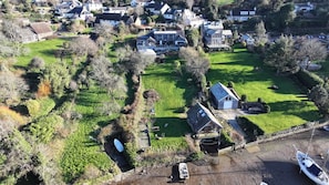 Luchtbeeld van een woonwijk met huizen, een gazon en een steiger met boten.