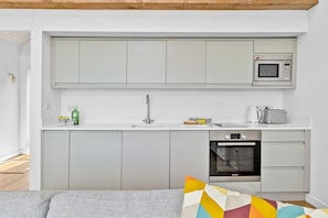 Een kleine keuken met een magnetron, broodrooster en oven.
