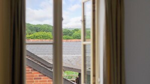 A view through a window with a brick wall and a green landscape. - The Hayloft (Queen Bower)