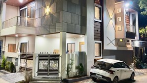 A modern two-story house with a car parked in front.