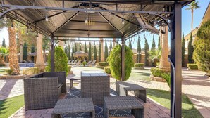 A covered outdoor seating area with wicker furniture and a pergola structure. - 12 Mi to the Strip: Las Vegas Home w/ Luxe Oasis! (Las Vegas)