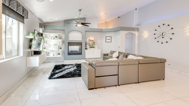A spacious living area with a sectional sofa, a fireplace, and a wall clock. - 12 Mi to the Strip: Las Vegas Home w/ Luxe Oasis! (Las Vegas)