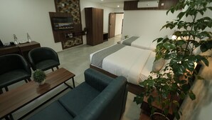 Een moderne hotelkamer met een bed, bureau, televisie en zithoek.
