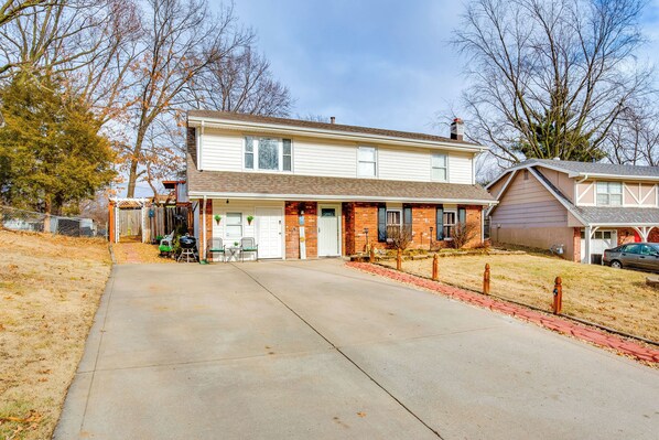 A two-story house with a front porch, a garage, and a driveway.