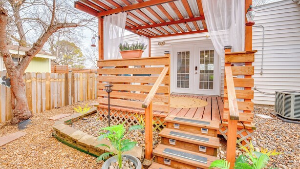 A wooden deck with a covered porch, a potted plant, and a small garden area with stepping stones. - 10 Mi to Dtwn Kansas City: Cozy Studio w/ Grill! (Kansas City)