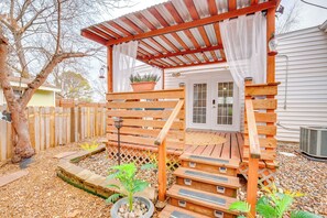 A wooden deck with a covered porch, a potted plant, and a small garden area with stepping stones.