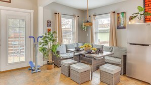 A modern living room with a sofa set, a dining table, and a standing fan. - 10 Mi to Dtwn Kansas City: Cozy Studio w/ Grill! (Kansas City)