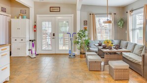 A spacious kitchen with a dining area, a ceiling fan, and a large window with curtains. - 10 Mi to Dtwn Kansas City: Cozy Studio w/ Grill! (Kansas City)