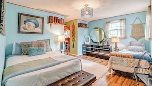 A bedroom with two beds, a dresser, a mirror, and a hanging macrame wall hanging. - 6 Mi to Downtown: 70s-Themed Home in Nashville! (Nashville)