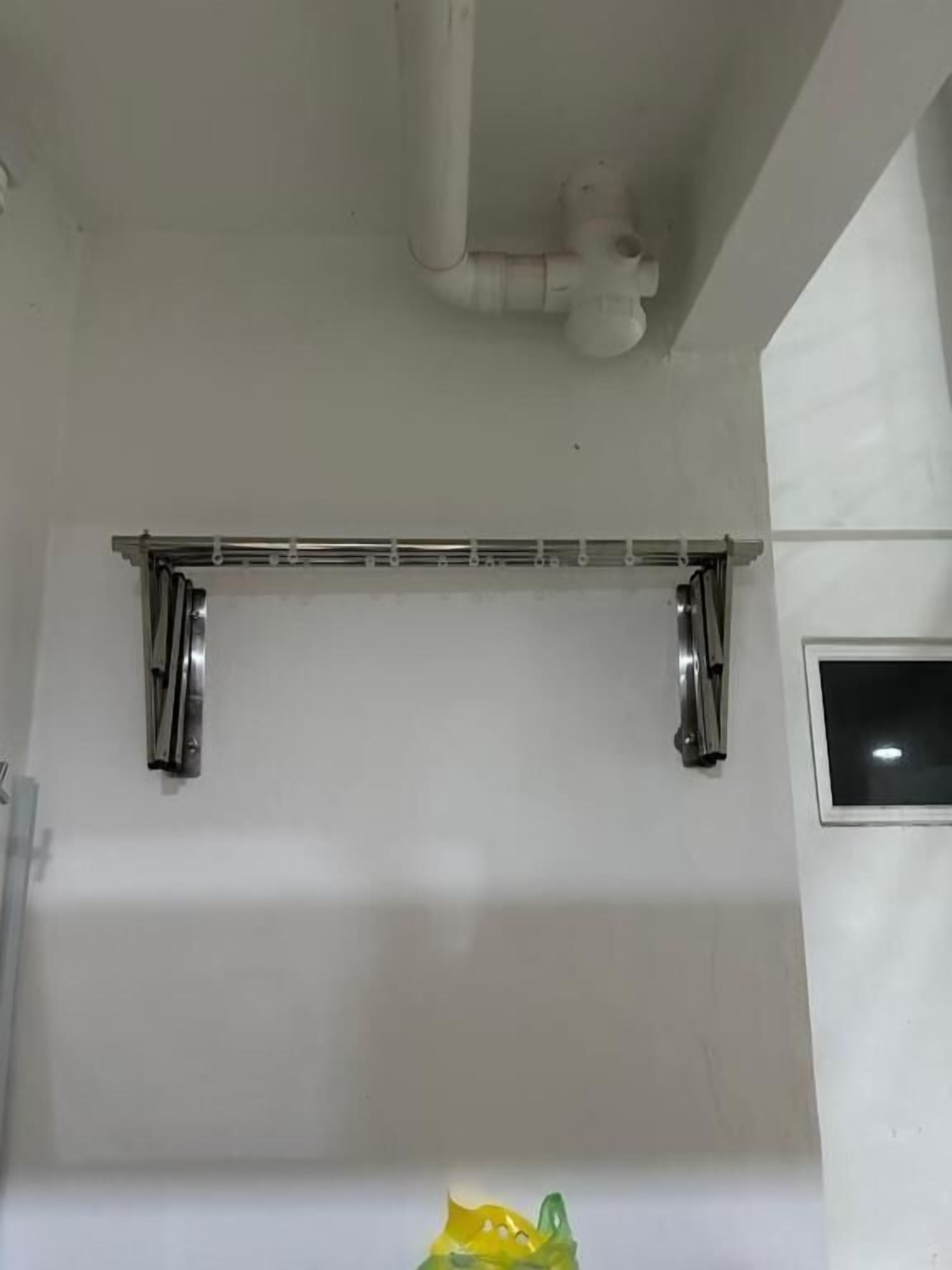 A bathroom with a white bathtub, a towel rack, and a window.