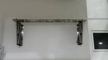 A bathroom with a white bathtub, a towel rack, and a window.