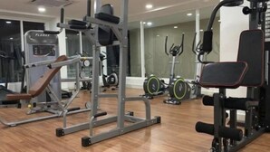 A gym with various exercise equipment, including a bench, weight machines, and cardio machines. - Champs Elysees Homestay by Landmark (Kampar)