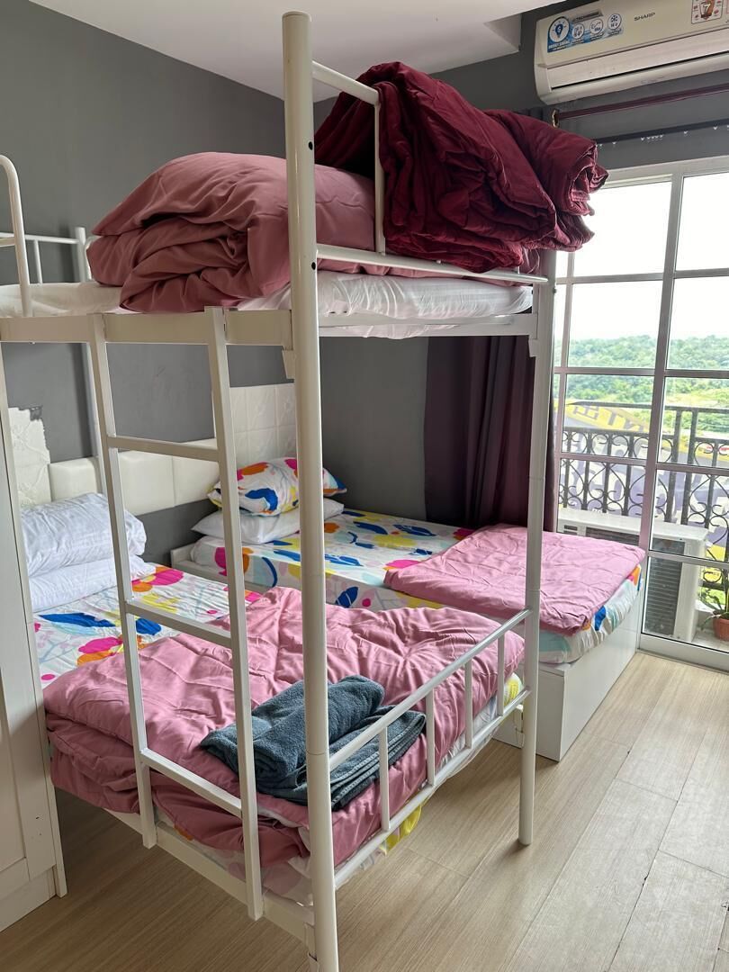 A bunk bed room with a window and an air conditioning unit.