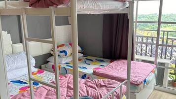 A bunk bed room with a window and an air conditioning unit.