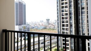 A high-rise building with a view of a cityscape, including a road with vehicles and a construction site. - R&F Hotel and Apartment (Phnom Penh)