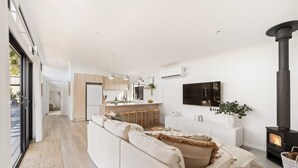Ein modernes Wohnzimmer mit einer Couch, einem Fernseher und einem Kamin.