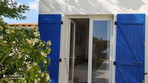 A white building with blue shutters and a glass door. - Seasonal rental Oleron (Saint-Georges-d'Oléron)