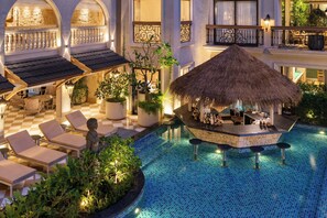 A pool area with lounge chairs, a bar, and a thatched-roof structure. - The Evren, Vagator - Small Luxury Hotels of the World (Vagator)