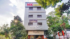 Un edificio de varios pisos con letreros que indican 'Hotel MK Residency' y 'Ranjatra'.