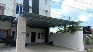 A building with a covered entrance, a signboard, and a potted plant. - Medina House Syariah Aceh (Banda Aceh)