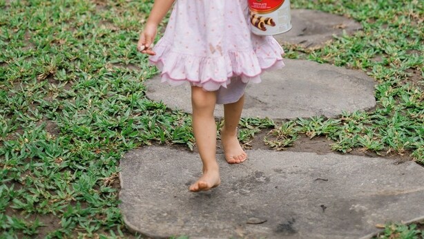 A child walking on a stone pathway in a garden area. - Kemuning Living Sanur (Denpasar)