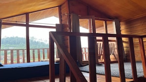 Een houten hut met een slaapzolder, een houten terras en uitzicht op het omliggende landschap.