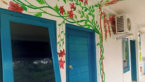 A hallway with blue doors and a wall painted with floral designs.
