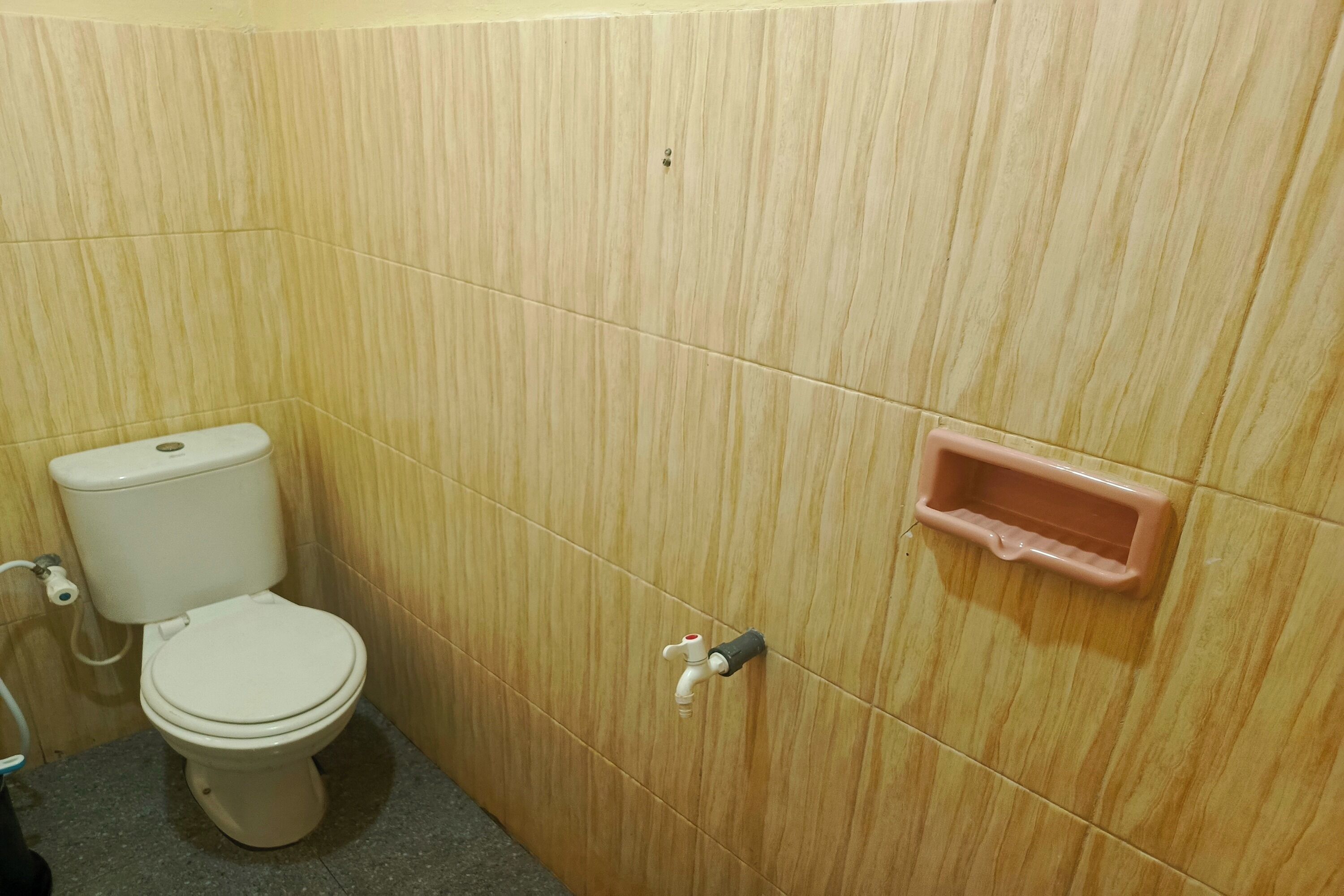 Un baño con inodoro, lavamanos y un pequeño armario.
