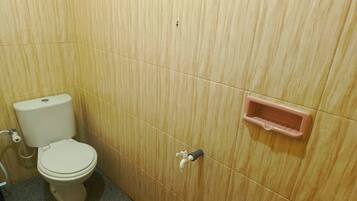 Un baño con inodoro, lavamanos y un pequeño armario.